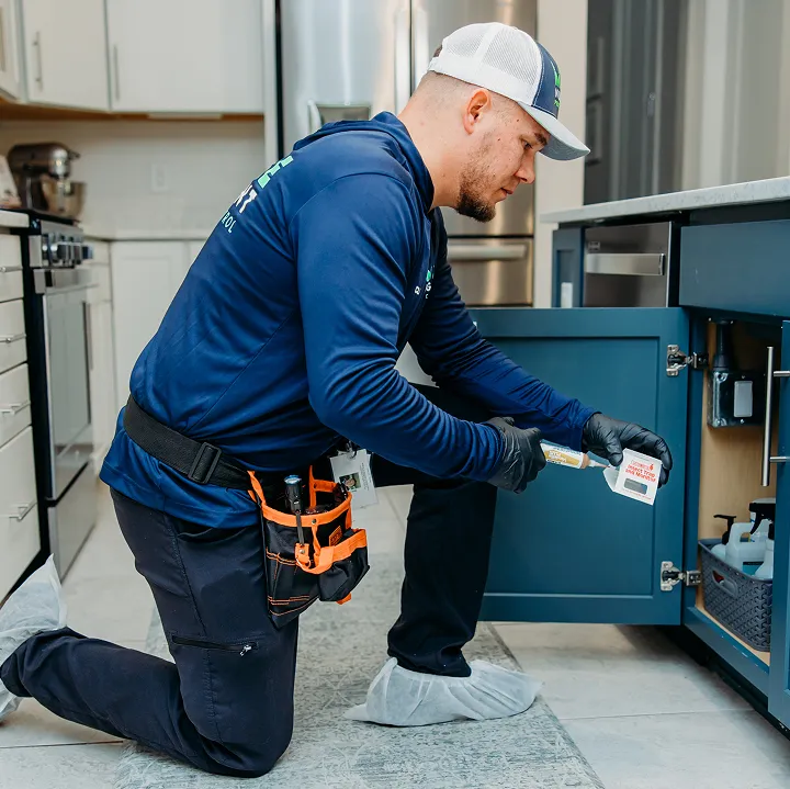 Pest control technician placing cockroach bait during an interior inspection