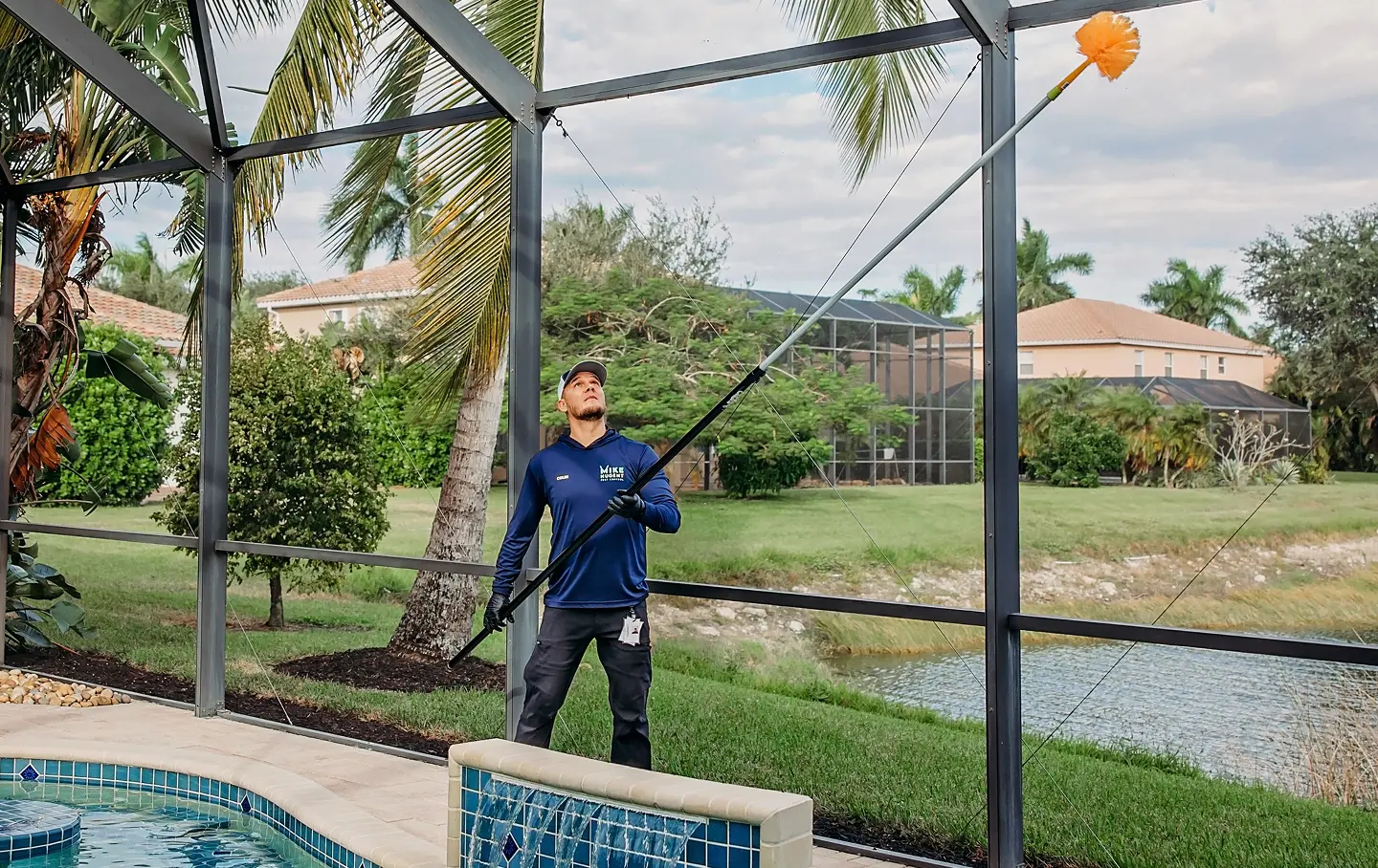 Pest control worker with large item reaching to top of pool cage